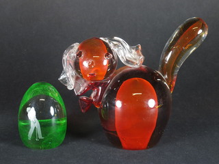 A Caithness green glass paperweight decorated a golfer 3" and a  red glass paperweight in the form of a dog 6"