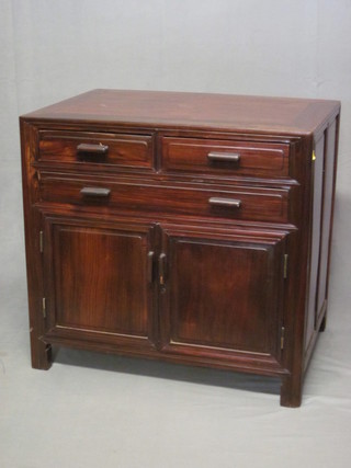 An Oriental Padouk cabinet fitted 2 short and 1 long drawer  above a double cupboard 34"w x 32"h x 22 1/2"d