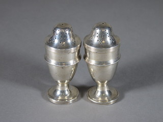 A pair of Georgian style silver pepperettes raised on spreading feet, Chester 1911, 1 ozs