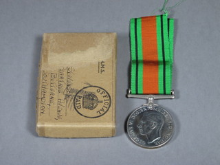 A Defence medal, boxed together with a Royal British Legion  lapel badge