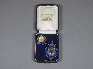 A silver and enamel sporting medallion and a gilt metal enamel brooch