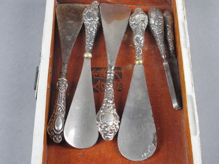 4 silver handled shoe horns, a pair of silver handled tweezers  and a do. nail file