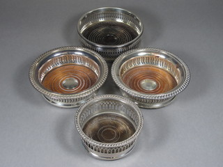 A pair of circular pierced silver plated bottle coasters and 2 others