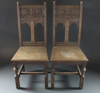 A pair of carved oak hall chairs with solid seats and backs