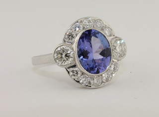 A lady's 18ct white gold dress ring set an oval cut tanzanite surrounded by diamonds, approx 0.85ct