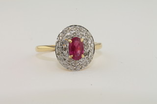 A lady's 18ct yellow gold cluster dress ring set a ruby surrounded by diamonds