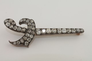 A gold brooch in the form of a Kris dagger set diamonds