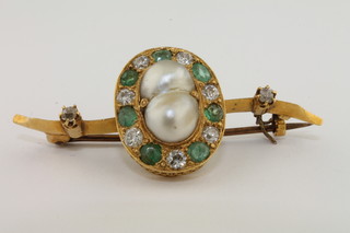 An oval gold brooch set pearls and diamonds