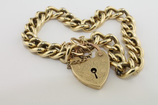 A gold curb link bracelet with padlock clasp