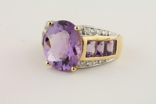 A 14ct yellow gold dress ring set an oval cut amethyst approx  5.50ct with baguette cut diamonds approx 0.30ct to the  shoulders