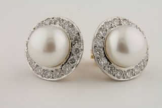 A pair of circular pearl and diamond earrings approx 1ct