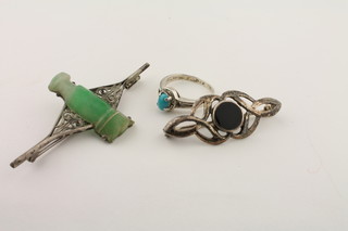 A silver brooch set an oval carved black stone, a silver ring set a cabouchon cut blue stone and a silver brooch set a green  hardstone urn