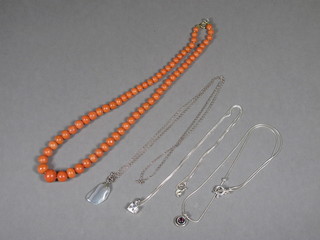 A string of coral beads and 3 silver chains hung pendants