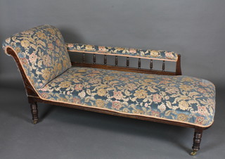 An Edwardian mahogany show frame chaise longue with bobbin  turned decoration, upholstered in floral material raised on turned  supports 67"