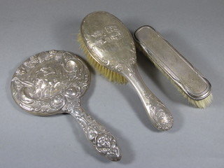 An embossed silver backed hand mirror, do. hair brush and  clothes brush