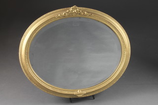 An oval bevelled plate wall mirror contained in a decorative gilt  frame 26" x 22"