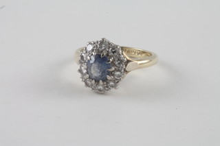 A lady's 18ct yellow gold dress ring set an oval cut sapphire surrounded by diamonds