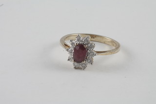 A lady's 9ct yellow gold dress ring set a ruby surrounded by  diamonds