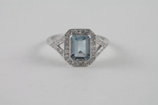 A lady's 18ct white gold dress ring set a rectangular cut aquamarine surrounded by diamonds