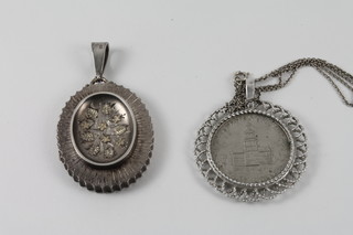 An oval engraved silver locket together with a silver chain hung a 1976 half dollar