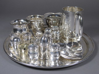 A silver plated pint tankard, circular tray, various pepper pots