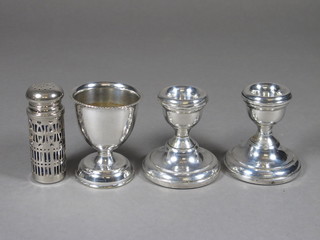 A pair of silver stub shaped candlesticks Birmingham 1973 2 1/2" and a silver plated egg cup and do. pepperette