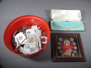 A collection of coins and a string of simulated pearls