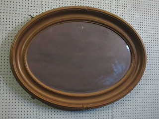 An oval plate wall mirror contained in a decorative gilt frame 37"w x 27 1/2"h