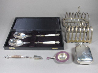 An enamelled silver and pink enamelled tea strainer, a pair of silver plated salad servers with mother of pearl grips - cased, a   silver plated and stag horn mounted stilton scoop, pair of silver  plated toast racks and a silver plated hip flask
