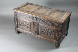 A 17th/18th Century carved oak coffer of panelled construction with hinged lid, the interior fitted a candle box above 2 drawers,  heavily carved throughout 43"w x 21"d x 23"h   ILLUSTRATED