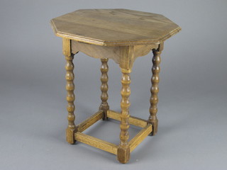A 1930's octagonal bleached oak occasional table, raised on  spiral turned and block supports 14"w x 15"h