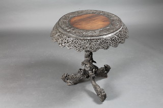 A circular heavily carved and pierced Eastern occasional table,  raised on pillar and tripod supports 25" x 28"