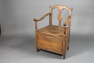 An 18th Century oak open arm commode chair