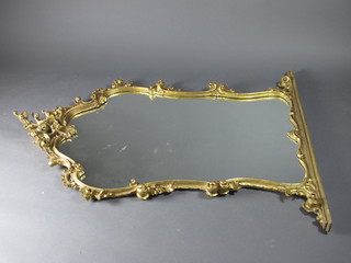 A shaped plate mirror contained in a decorative carved frame