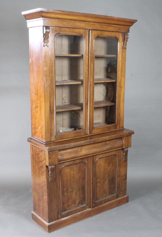 A Victorian mahogany display cabinet on cabinet, the upper section with moulded cornice, the shelved interior enclosed by  arched panelled doors, the base fitted a cupboard enclosed by  panelled doors 43"w x 15 1/2"d x 79"h