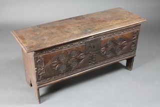 An 18th Century carved oak coffer of panelled construction with  iron lock, the interior fitted a candle box, 43 1/2"w x 15" x  21"h
