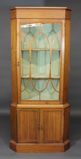 A 19th Century inlaid mahogany double corner cabinet with  moulded cornice, fitted shelves enclosed by astragal glazed  panelled doors, the base fitted a cupboard enclosed by panelled  doors, raised on a platform base 34"w x 80"h x 19 1/2"d