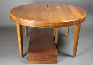 An Art Deco Continental walnut oval extending dining table  raised on 6 square tapering supports 52" x 43" x 29", with 2  extra leaves