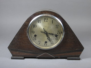 A 1930's Art Deco 8 day chiming mantel clock with silvered dial  and Arabic numerals contained in an oak arch shaped case by  Enfield
