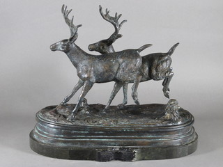 A bronze figure group of 2 running deer raised on an oval base  15"