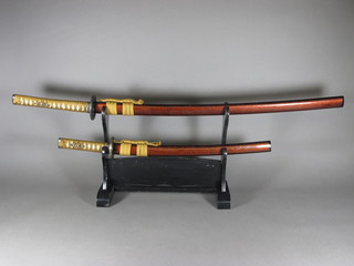 A reproduction Japanese Kutana and 1 other sword, on a  lacquered stand