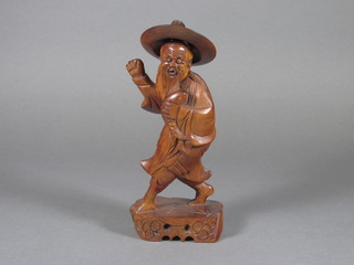 An Oriental carved wooden figure of a standing gentleman 8"