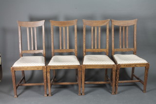 A set of 4 Edwardian Art Nouveau oak stick and rail back dining  chairs with upholstered drop in seats