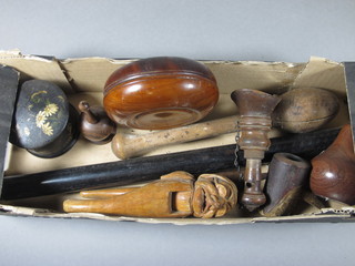 A pair of turned olive wood campaign candlesticks, a pair of wooden nut crackers and other items of treen