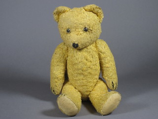 A gold articulated teddy bear with glass eyes, sewn nose and  toes and a hump