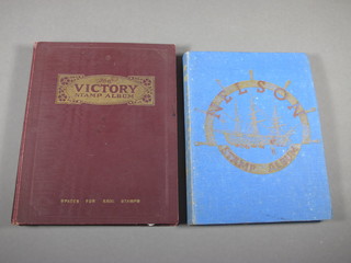 A blue Nelson album of stamps and a brown Victory album of  stamps