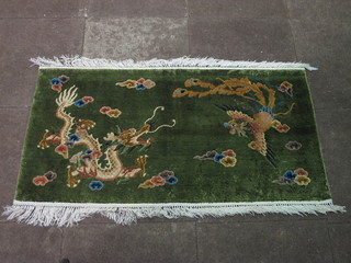 A green ground Chinese rug decorated dragons 49" x 25"
