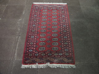 A red Bokhara rug with 22 octagons to the centre 65" x 37"