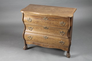 A Continental serpentine fronted oak chest of 3 long drawers,  raised on hoof supports 29"w x 14 1/2"d x 26"h