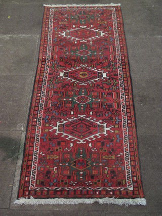 A red ground Persian runner with 7 octagons to the centre 75" x  28"